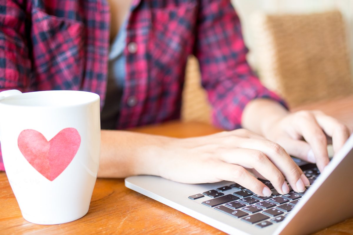 laptop and coffee mug with a heart on it