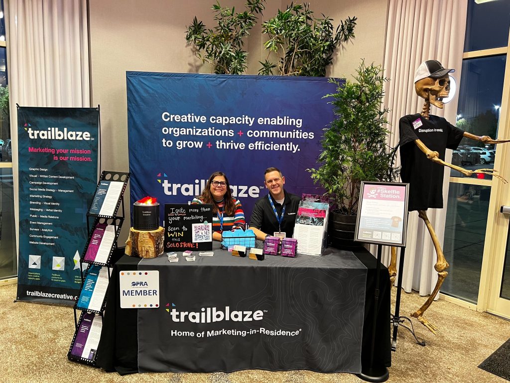 Tim Hindes and Erin Sogal sitting at TrailBlaze table.
